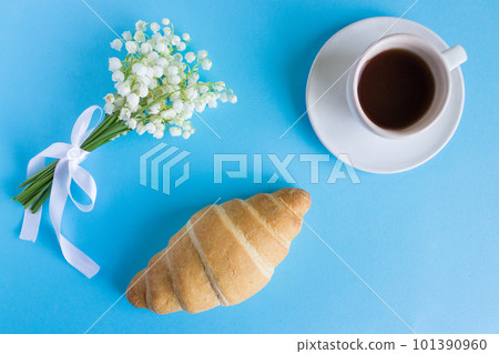 Coffee mug with bouquet of flowers lily of the valley and notes good morning, beautiful breakfast, top view, flat lay. croissant and coffee 101390960