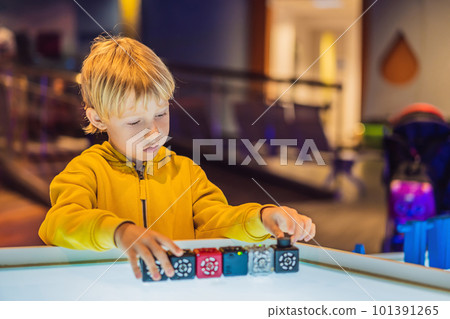 The boy plays with the electronic designer on the light table The boy plays with the electronic designer on the light table 101391265