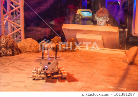 The boy controls the toy rover on Mars. Flight to Mars concept The boy controls the toy rover on Mars. Flight to Mars concept 101391297