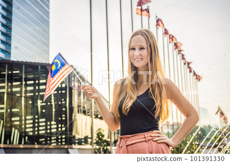Young woman travels in Malaysia. Holds the Malaysian flag Young woman travels in Malaysia. Holds the Malaysian flag 101391330
