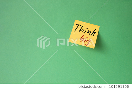 Think big symbol. Orange steaky note with words Think big. Beautiful green background. Business and Think big concept. Copy space. Think big symbol. Orange steaky note with words Think big. Beautiful green background. Business and Think big concept. Copy space. 101391506