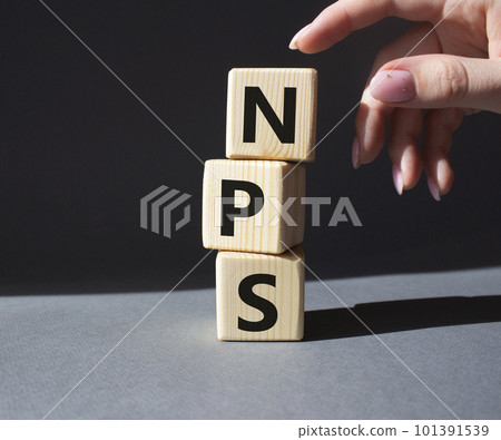 NPS - Net Promoter Score symbol. Wooden cubes with words NPS. Businessman hand. Beautiful grey background. Business and NPS concept. Copy space. NPS - Net Promoter Score symbol. Wooden cubes with words NPS. Businessman hand. Beautiful grey background. Business and NPS concept. Copy space. 101391539