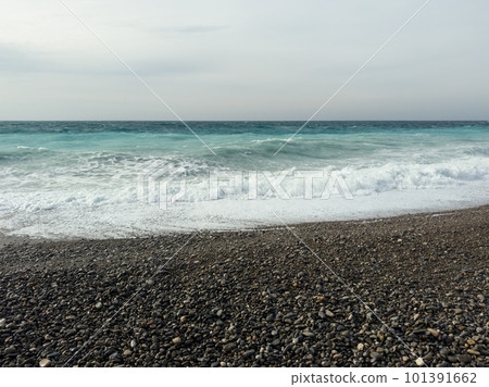 Pebble beach of Nice, France with azure waves of mediterranean sea 101391662
