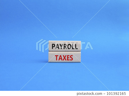 Payroll taxes symbol. Concept word Payroll taxes on wooden blocks. Beautiful blue background. Businessman hand. Business and Payroll taxes concept. Copy space 101392165