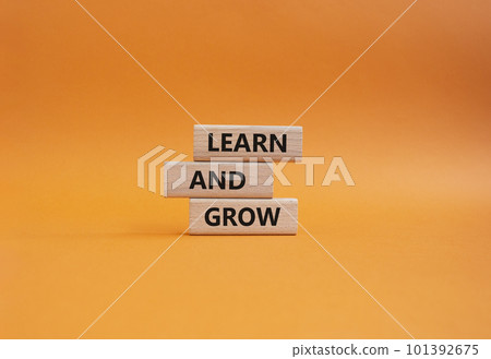 Learn and grow symbol. Concept words 'Learn and grow' on wooden blocks. Beautiful orange background. Business and Learn and grow concept. Copy space. 101392675