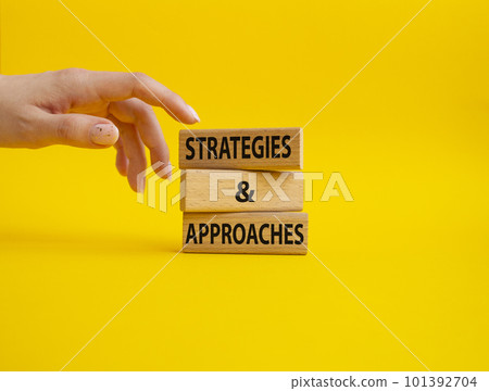 Strategies and approaches symbol. Concept word Strategies and approaches on wooden blocks. Beautiful yellow background. Businessman hand. Business and Strategies and approaches concept. Copy space 101392704