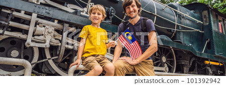 Father and son travelers in malaysia with malaysia flag celebrating the Malaysia independence day and Malaysia day. Travel to Malaysia concept BANNER, LONG FORMAT 101392942