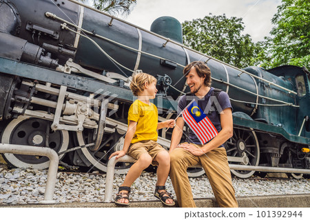 Father and son travelers in malaysia with malaysia flag celebrating the Malaysia independence day and Malaysia day. Travel to Malaysia concept 101392944