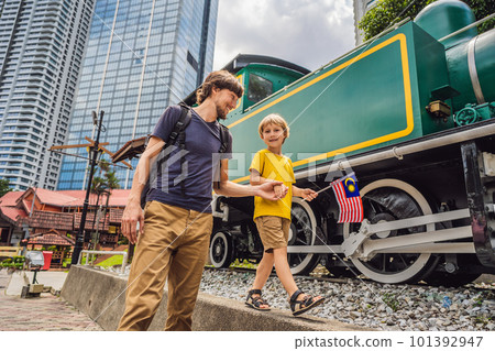Father and son travelers in malaysia with malaysia flag celebrating the Malaysia independence day and Malaysia day. Travel to Malaysia concept Father and son travelers in malaysia with malaysia flag celebrating the Malaysia independence day and Malaysia day. Travel to Malaysia concept 101392947