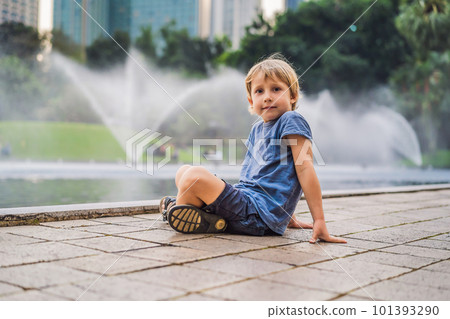 Boy on background of Fountain on the lake in the evening, near by Twin Towers with city on background. Kuala Lumpur, Malaysia 101393290