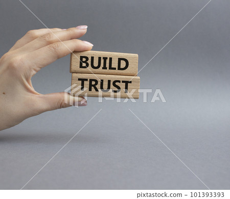 Build trust symbol. Wooden blocks with words Build trust. Beautiful grey background. Businessman hand. Business and Build trust concept. Copy space. Build trust symbol. Wooden blocks with words Build trust. Beautiful grey background. Businessman hand. Business and Build trust concept. Copy space. 101393393