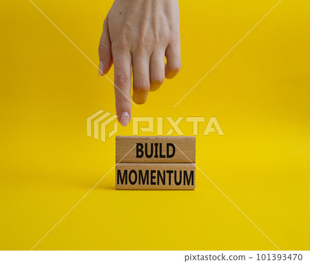 Build momentum symbol. Wooden blocks with words Build momentum. Beautiful yellow background. Businessman hand. Business and Build momentum concept. Copy space. Build momentum symbol. Wooden blocks with words Build momentum. Beautiful yellow background. Businessman hand. Business and Build momentum concept. Copy space. 101393470