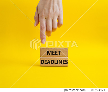 Meet Deadlines symbol. Concept word Meet Deadlines on wooden blocks. Beautiful blue background. Businessman hand. Business and Meet Deadlines concept. Copy space Meet Deadlines symbol. Concept word Meet Deadlines on wooden blocks. Beautiful blue background. Businessman hand. Business and Meet Deadlines concept. Copy space 101393471