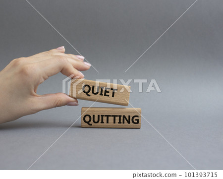Quiet quitting symbol. Concept word Quiet quitting on wooden blocks. Beautiful grey background. Businessman hand. Business and Quiet quitting concept. Copy space. Quiet quitting symbol. Concept word Quiet quitting on wooden blocks. Beautiful grey background. Businessman hand. Business and Quiet quitting concept. Copy space. 101393715