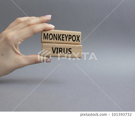 Monkeypox virus symbol. Concept word Monkeypox virus on wooden blocks. Beautiful grey background. Doctor Hand. Medicine and Monkeypox virus concept. Copy space 101393732
