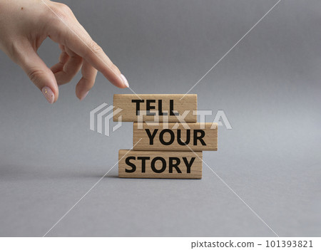 Tell your story symbol. Wooden blocks with words Tell your story. Beautiful grey background. Businessman hand. Business and Tell your story concept. Copy space. 101393821