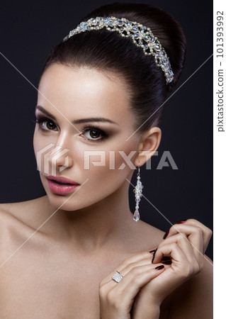 Beautiful brunette girl with perfect skin, evening make-up, wedding hairstyle and accessories. Beauty face. Beautiful brunette girl with perfect skin, evening make-up, wedding hairstyle and accessories. Beauty face. 101393992