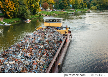 Transportation industry. Ship barge transports scrap metal and sand with gravel. Barge loaded with scrap metal is on the roadstead. Scrap metal transportation by water. Barge laden by metal salvage Transportation industry. Ship barge transports scrap metal and sand with gravel. Barge loaded with scrap metal is on the roadstead. Scrap metal transportation by water. Barge laden by metal salvage 101394312