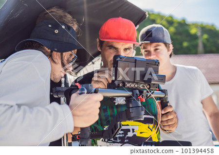 Steadicam operator and his assistant prepare camera and 3-axis stabilizer-gimbal for a commercial shoot 101394458