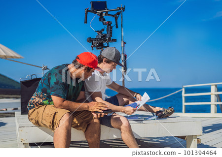 camera operator and director discuss the process of a commercial video shoot camera operator and director discuss the process of a commercial video shoot 101394464