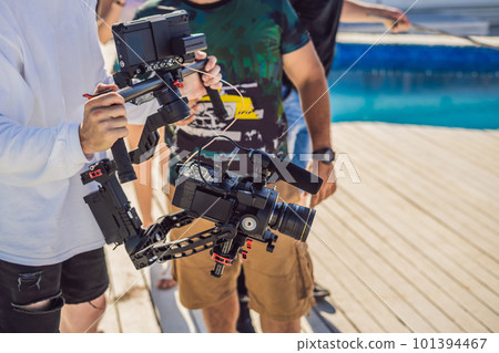 Professional steadicam operator uses a 3-axis camera stabilizer system on a commercial production set Professional steadicam operator uses a 3-axis camera stabilizer system on a commercial production set 101394467