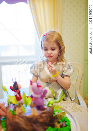 little girl with a large cake with figures of fairy-tale characters 101395043