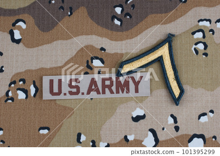 US ARMY branch tape and private rank patch on desert camouflage uniform background 101395299