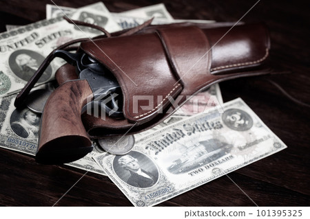 Old west Colt Peacemaker and US banknotes and silver certificates with silver dollar coins and .45 caliber revolver ammunitions 101395325