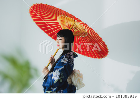 一個穿著浴衣的女人拿著一把日本傘 101395919