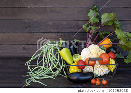Organic farm vegetables on a dark wooden table. Fresh raw cauliflower, green beans, zucchini, corn, beets. Copy space. 101398088