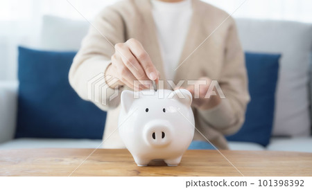 Asian woman putting coin in piggy bank. Save money and investment concept 101398392