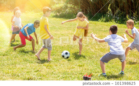 Cheerful children are jogning with ball on playground Cheerful children are jogning with ball on playground 101398625