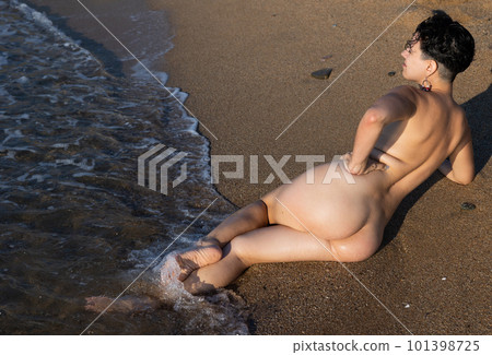 Naked young adult woman lying on beach 101398725