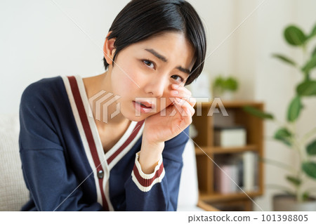 在客廳裡痛苦的年輕女子 在客廳裡痛苦的年輕女子 101398805