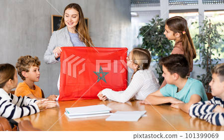 Teacher showing Morocco flag to group of schoolchildren Teacher showing Morocco flag to group of schoolchildren 101399069