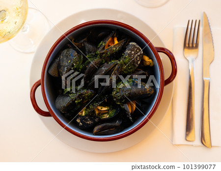 Picture of steamed tasty mussels served on pan with lemon 101399077
