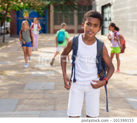 African american preteen boy with backpack walking outdoors 101399153