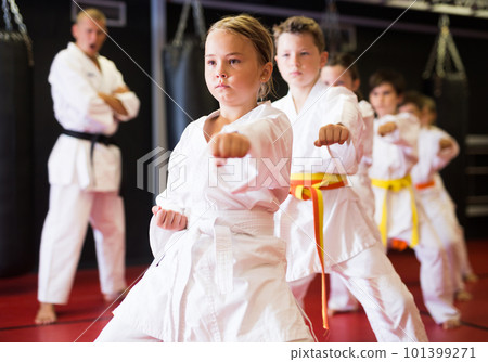 Girl practicing new moves during karate class Girl practicing new moves during karate class 101399271