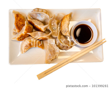 Plate of fried Chinese dumplings and bowl of soy sauce with chopsticks Plate of fried Chinese dumplings and bowl of soy sauce with chopsticks 101399281