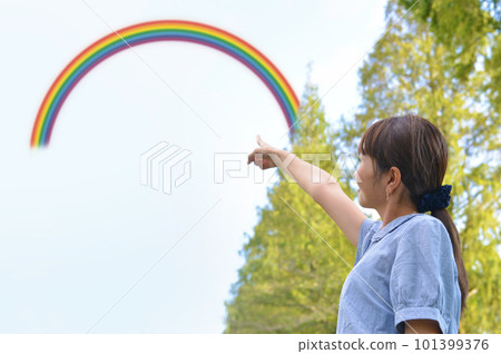 woman pointing towards the rainbow woman pointing towards the rainbow 101399376