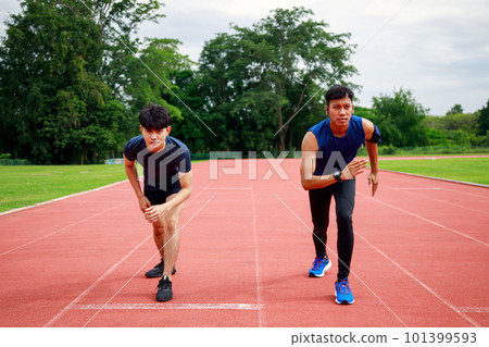Two young Fit and confident Asian teenagers in starting position ready for running Two young Fit and confident Asian teenagers in starting position ready for running 101399593