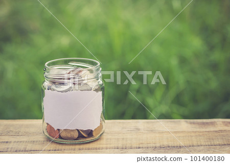 Money in the jar on wooden table 101400180