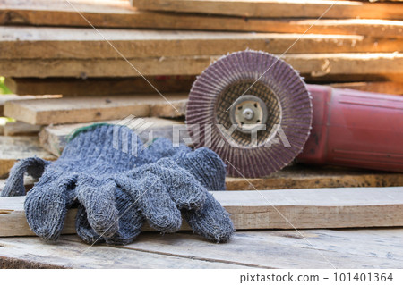 Gloves and electric sandpaper tool on wooden table Gloves and electric sandpaper tool on wooden table 101401364