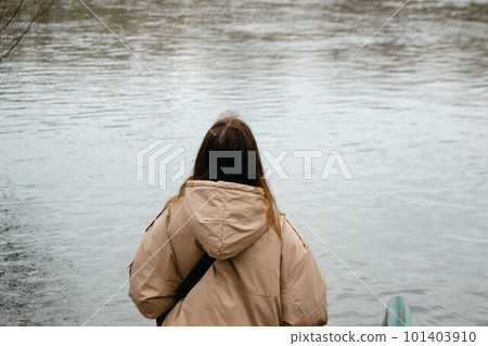 A woman with long brown hair near river in spring. High quality photo A woman with long brown hair near river in spring. High quality photo 101403910