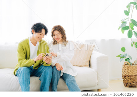 A young couple looking at a smartphone together 101405220