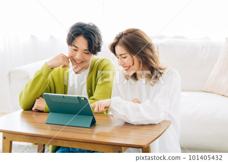一對年輕夫婦（夫婦）一起看平板電腦 101405432