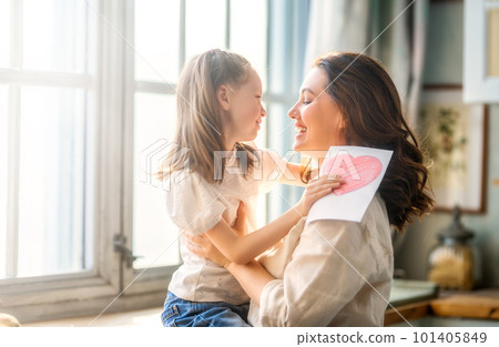 Daughter giving mother postcard. 101405849