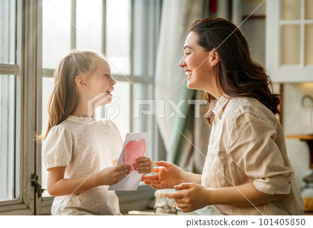 Daughter giving mother postcard. 101405850