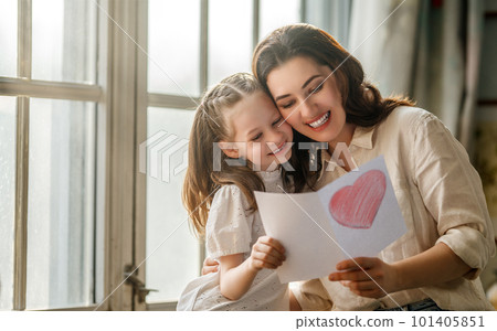 Daughter giving mother postcard. 101405851