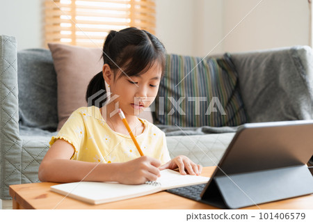 Asian little girl doing homework, learning, student using digital tablet. Asian little girl doing homework, learning, student using digital tablet. 101406579